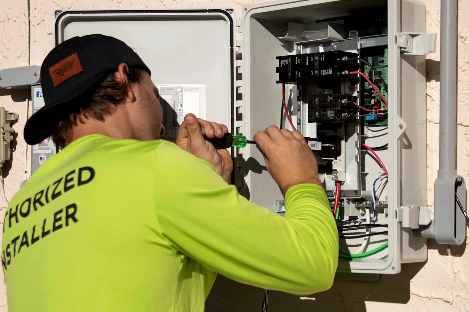 Electrician servicing an exterior electrical panel