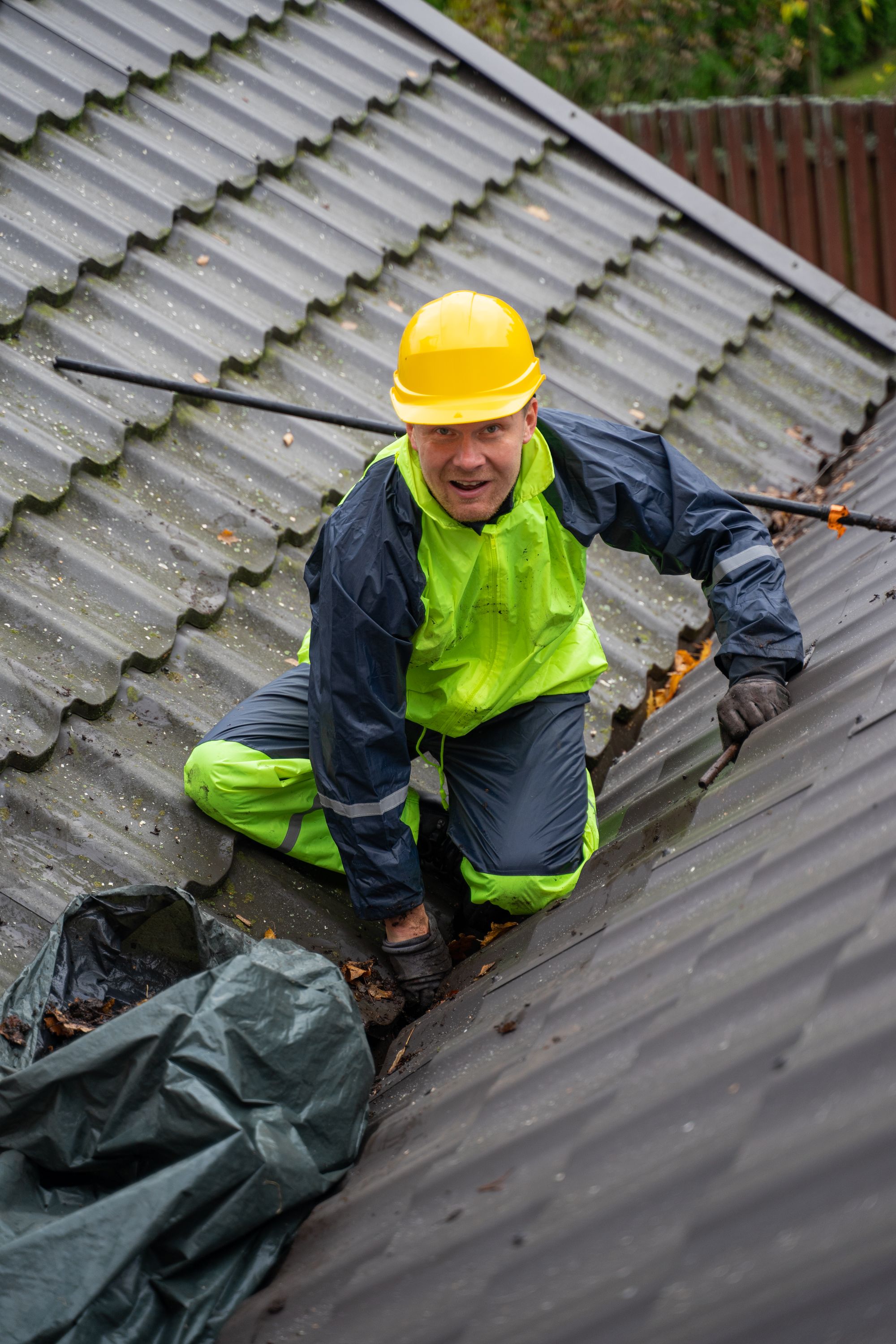 A roofing specialist inspecting a tiled roof