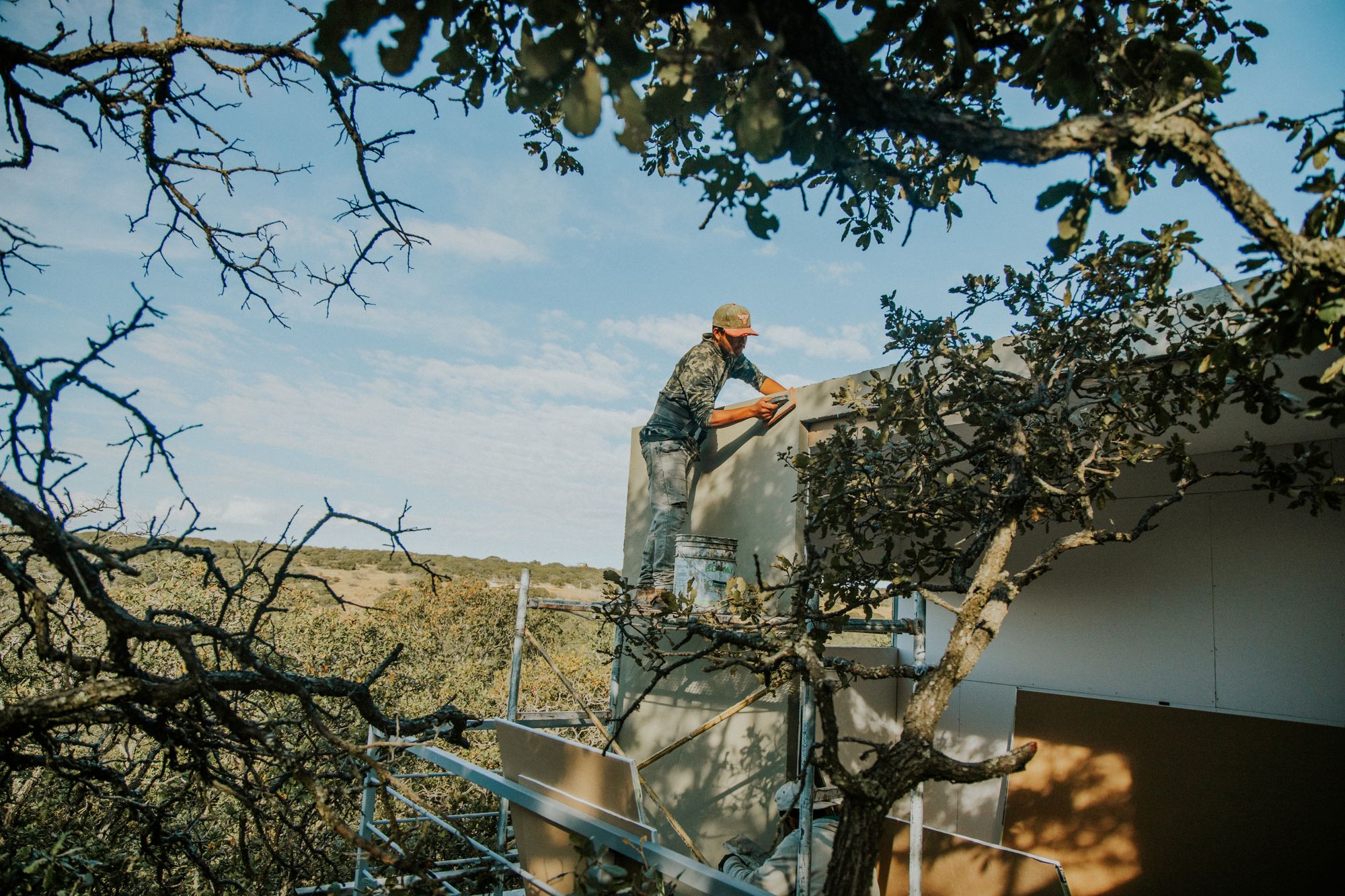 A roofing professional working safely on a residential roof