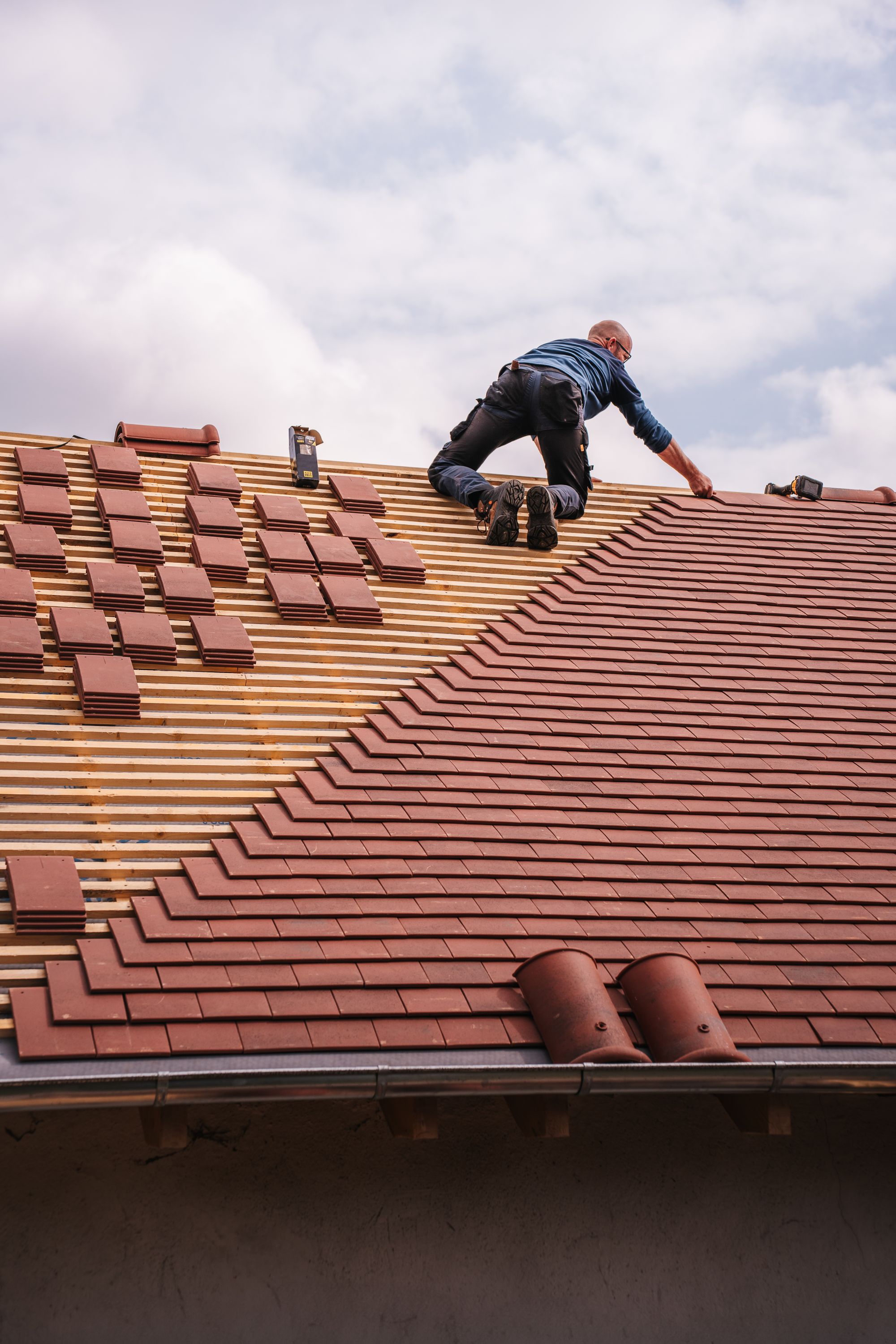 A roofer installing new roof tiles