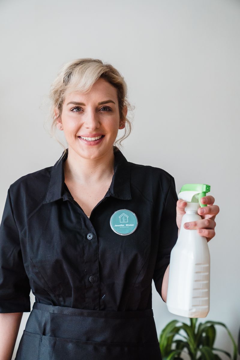 Cleaner in overalls mopping a kitchen floor