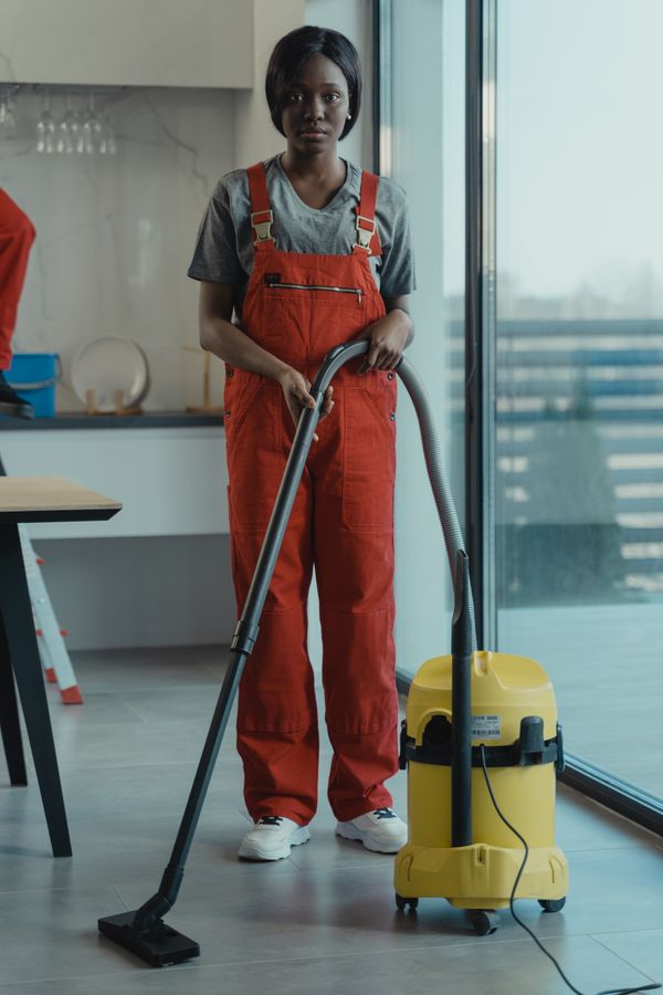 Cleaner vacuuming a carpeted room