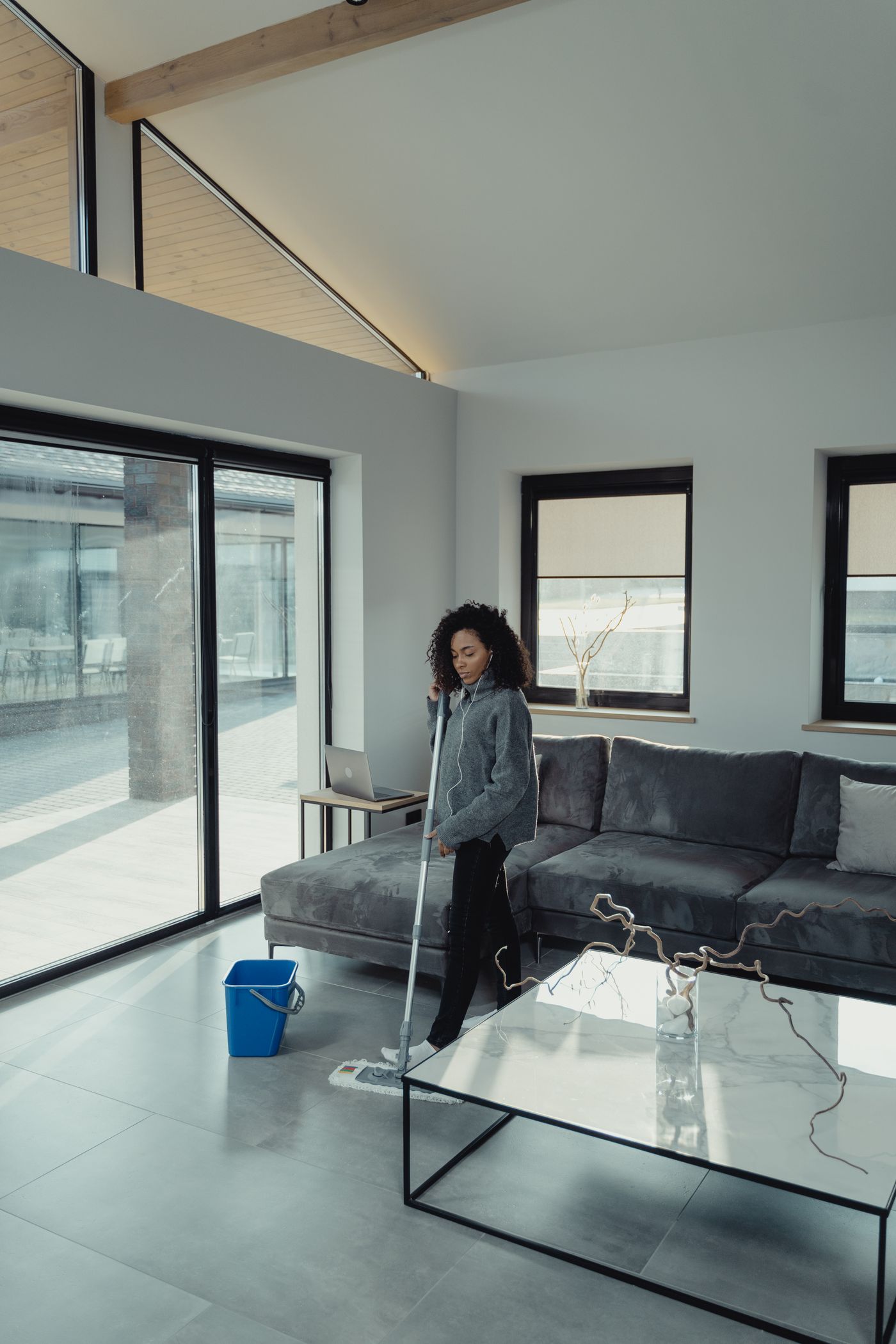 Professional cleaner mopping a floor in a bright modern home