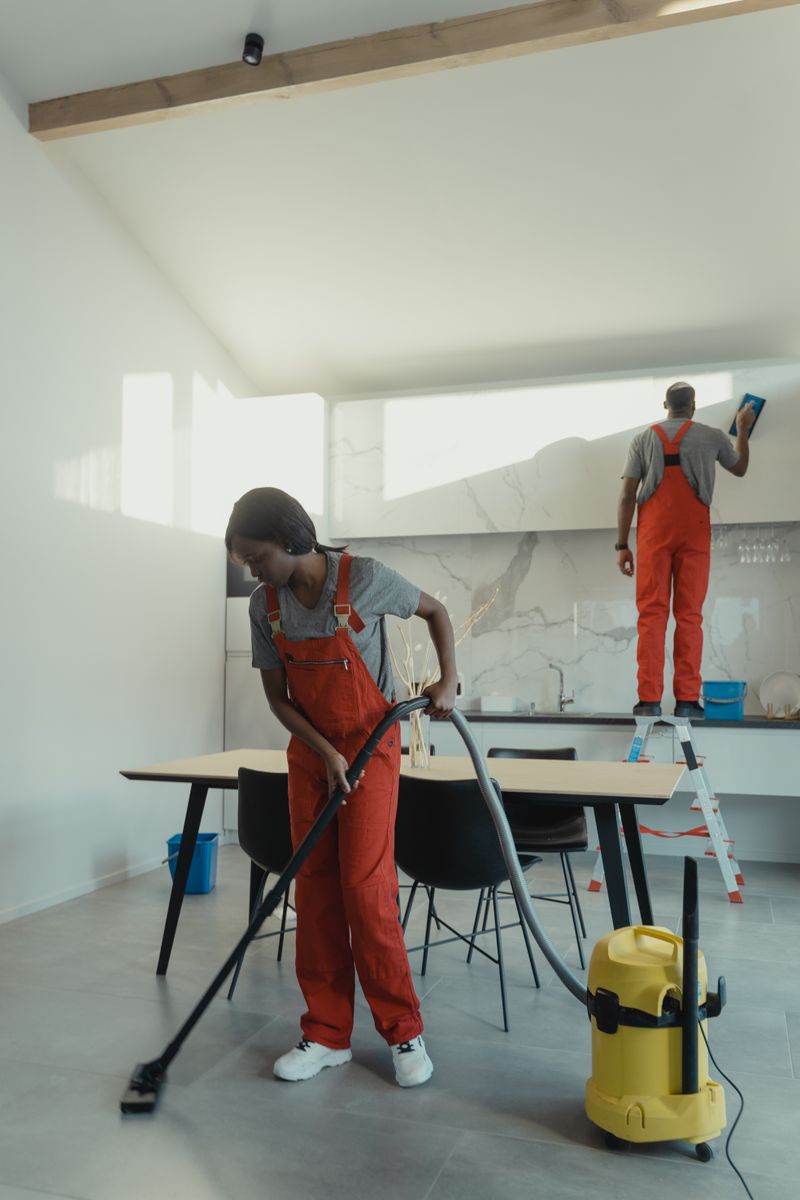Cleaners deep cleaning a modern kitchen with professional equipment