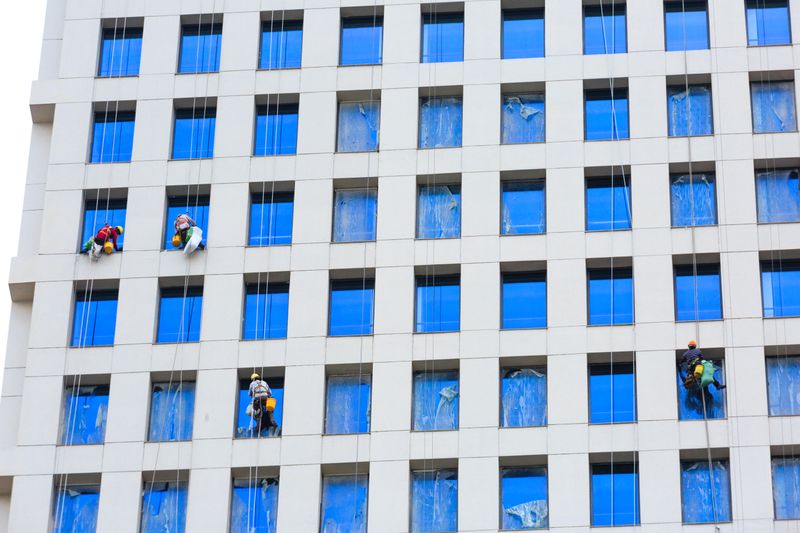 Window cleaners working on a glass building facade